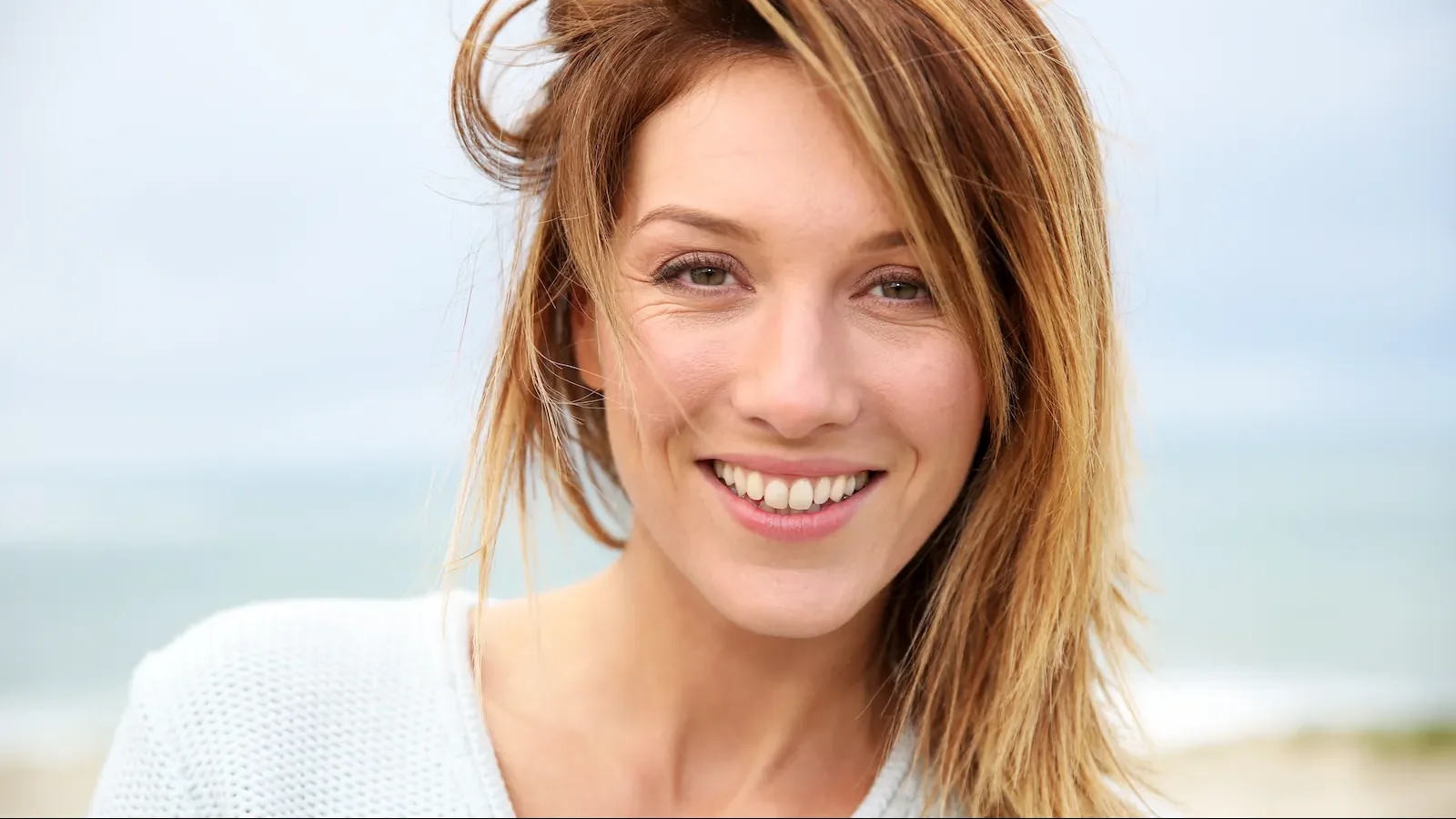 Beautiful mature woman smiling on beach