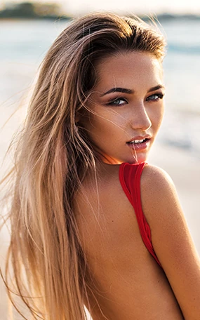 Beautiful girl looking over shoulder at the beach