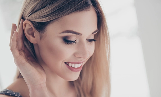 Smiling woman tucking her hair behind her ear