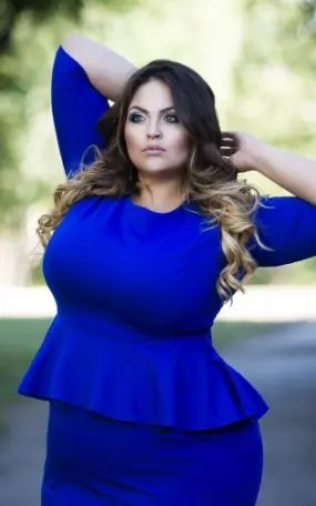 Young beautiful plus size model in blue dress