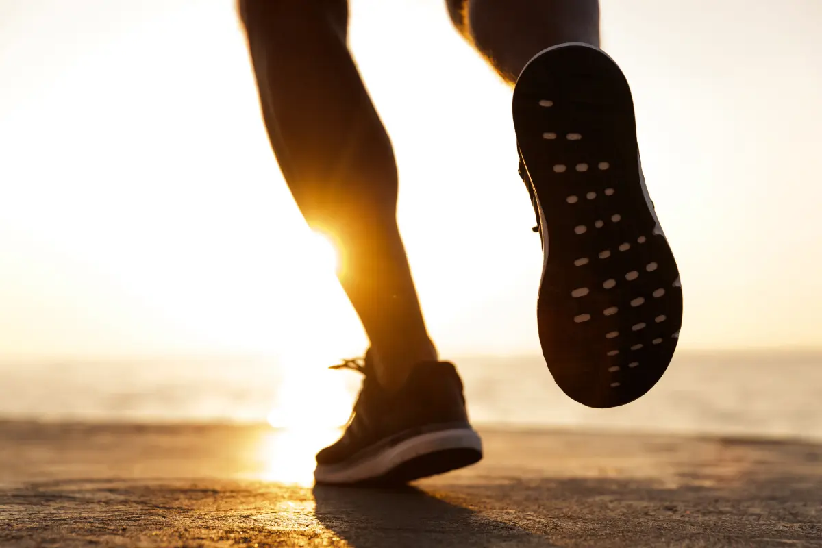 man running into sunset with strong legs