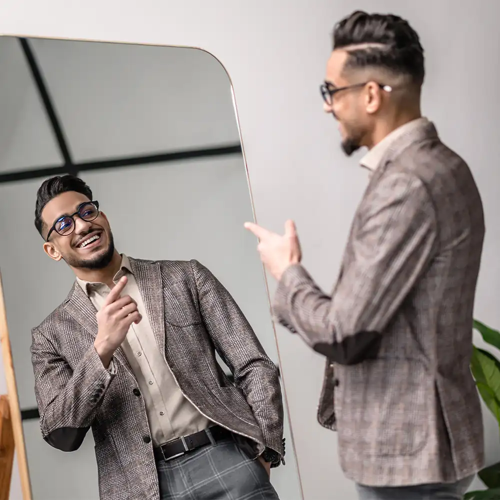 Confident happy man smiling in the mirror